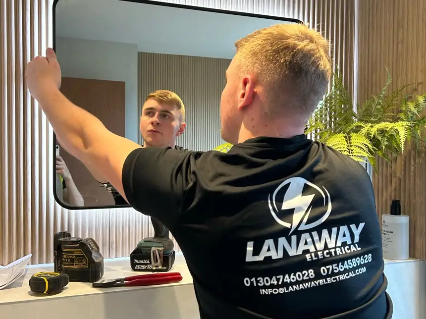Illuminated bathroom mirror being fitted by a Lanaway electrician